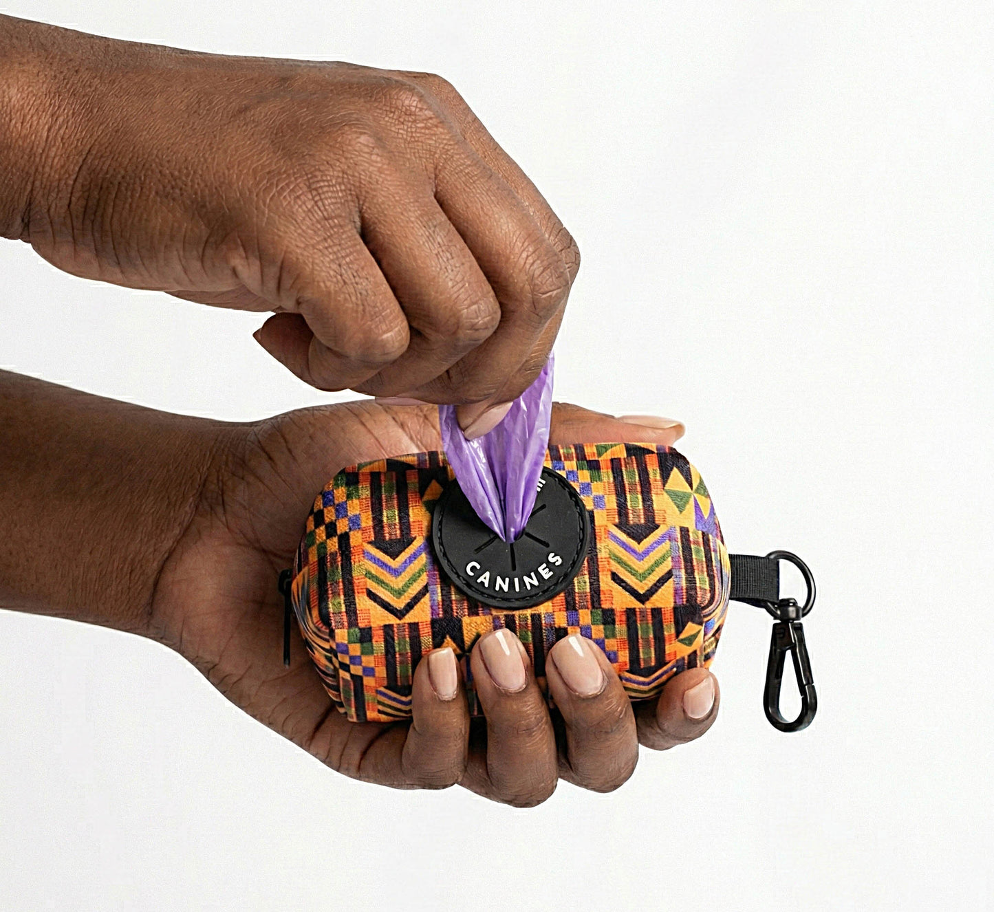 Hand holding a Kente Canines Gold Rush yellow dog waste poop bag dispenser with 'Kente Canines' branding.
