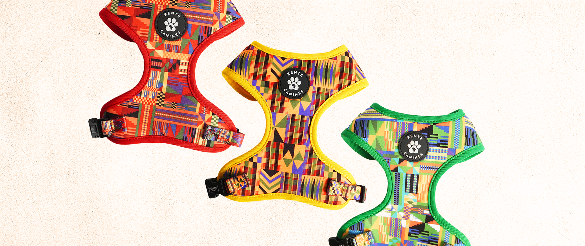 Kente Canines Three colorful dog harnesses with the brand logo on a beige background